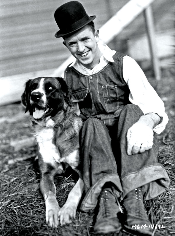 Stan Laurel takes a breather with his dog, Lady, in between takes on The Finishing Touch (Hal Roach Studios, 1928)